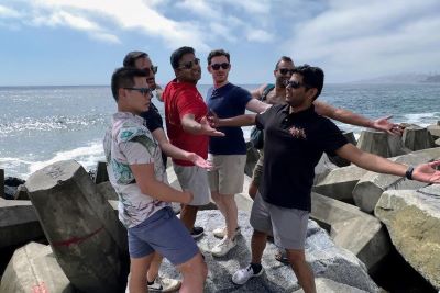 Photo of a group of six OMBA students having fun on the beach in Chile. 