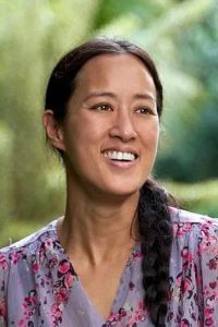 Photo of Cynthia Shih with a long dark braid wearing a flower patterned shirt. 