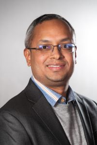 Photo of Ganesh Masti, Michigan Ross EMBA student wearing a dark gray suit jacket with a gray sweater 