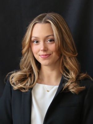 Rachel Gunder smiles with a dark background behind her.