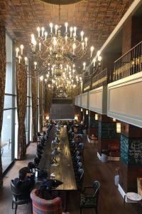 Photo of the lobby of The Graduate hotel in Ann Arbor with a big chandelier 