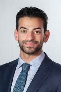 Photo of Kayan Sidhwa Michigan Ross EMBA student with short dark hair wearing a navy blue suit with a light blue shirt and a teal tie.