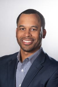 Photo of Matthew Cosby, Michigan Ross EMBA student wearing a navy blue suit and a light blue shirt