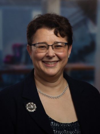 Susan. B Meyer smiling with a blue background