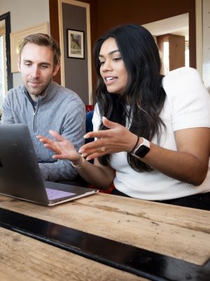 Photo of male student and female student discussing a project next to a computer in a cafe in Ireland. 