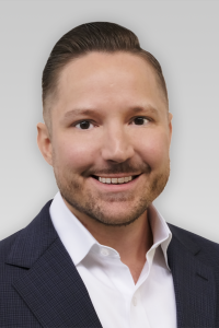 Photo of Ryan McWhirter Michigan Ross EMBA student who has brown hair wearing a navy blue suit with a white shirt. 