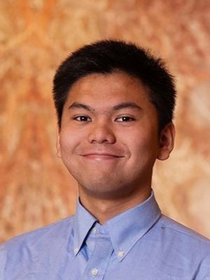 Kevin Silitonga smiles with an orange background behind him.