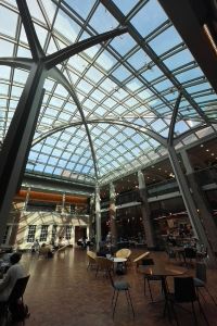 Photo of interior of the Michigan Union with a glass ceiling and tables and chairs.