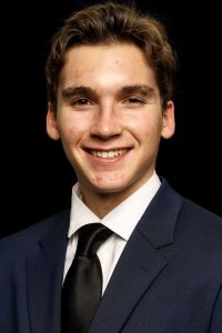 Photo of Wilder Wetzel-Righettini Michigan Ross BBA student wearing a black suit and tie with a white shirt and smiling 