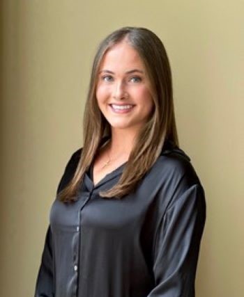 Claire Heritage headshot with a gold background