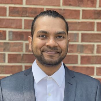 Male student with mustache and beard wearing a suit 