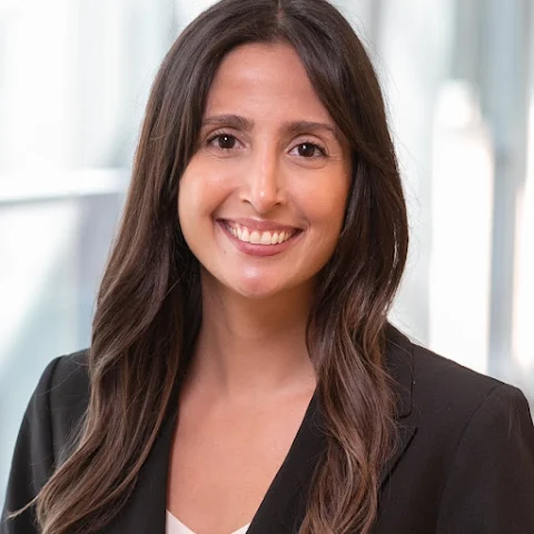 Woman with black blazer and long hair smiling