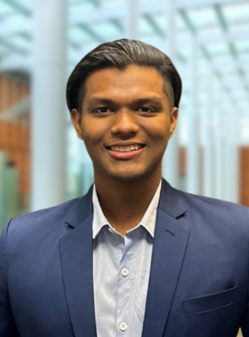 A man in a blue suit smiles in a professional headshot photo