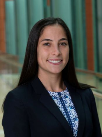 A woman in a blazer smiles in a professional headshot