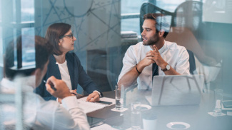 Group of Executive Education students talking at a table