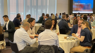 Photo of Michigan Ross Weekend MBA Orientation with many new students sitting at tables and collaborating