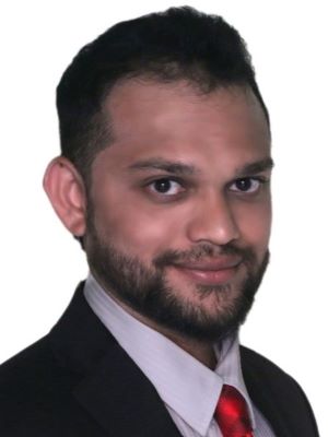 Sushrut Sardesai poses in a black suit in front of a white background