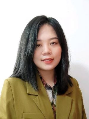 Tingting Xie poses in a green blazer in front of a white background